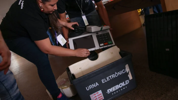 Mesária testa urna eletrônica destinada à votação no exterior, durante procedimento de lacração realizado pelo tribunal eleitoral
