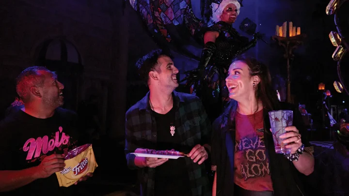 Três amigos riem juntos enquanto comem petiscos no Halloween Horror Nights na Universal Studios Florida