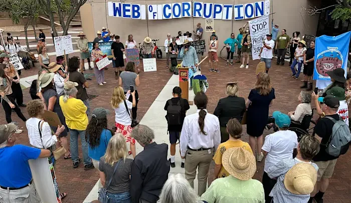 Manifestantes se reúnem em praça em Santa Fe contra projeto de data center de inteligência artificial, com faixa de protesto e cartazes de oposição visíveis ao fundo