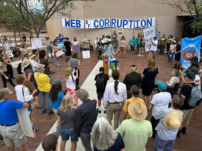 Manifestantes se reúnem em praça em Santa Fe contra projeto de data center de inteligência artificial, com faixa de protesto e cartazes de oposição visíveis ao fundo