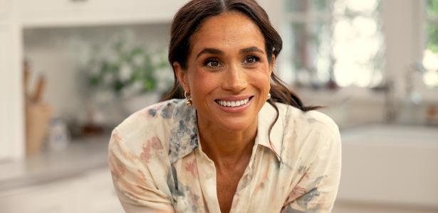 Mulher sorrindo durante conversa em ambiente interno, em cena que aparenta ser de produção audiovisual