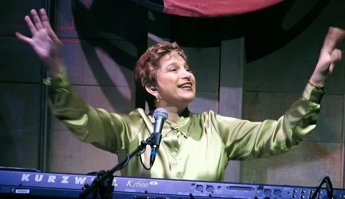 Carol sorrindo ao piano.
