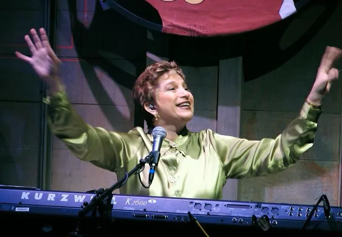 Carol sorrindo ao piano.