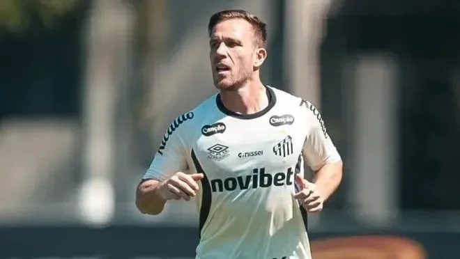 Jogador corre durante treino usando camisa com patrocínio de casa de apostas, em dia de sol