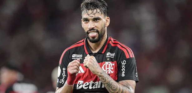 Jogador do Flamengo gesticula durante partida com o uniforme vermelho e preto do clube
