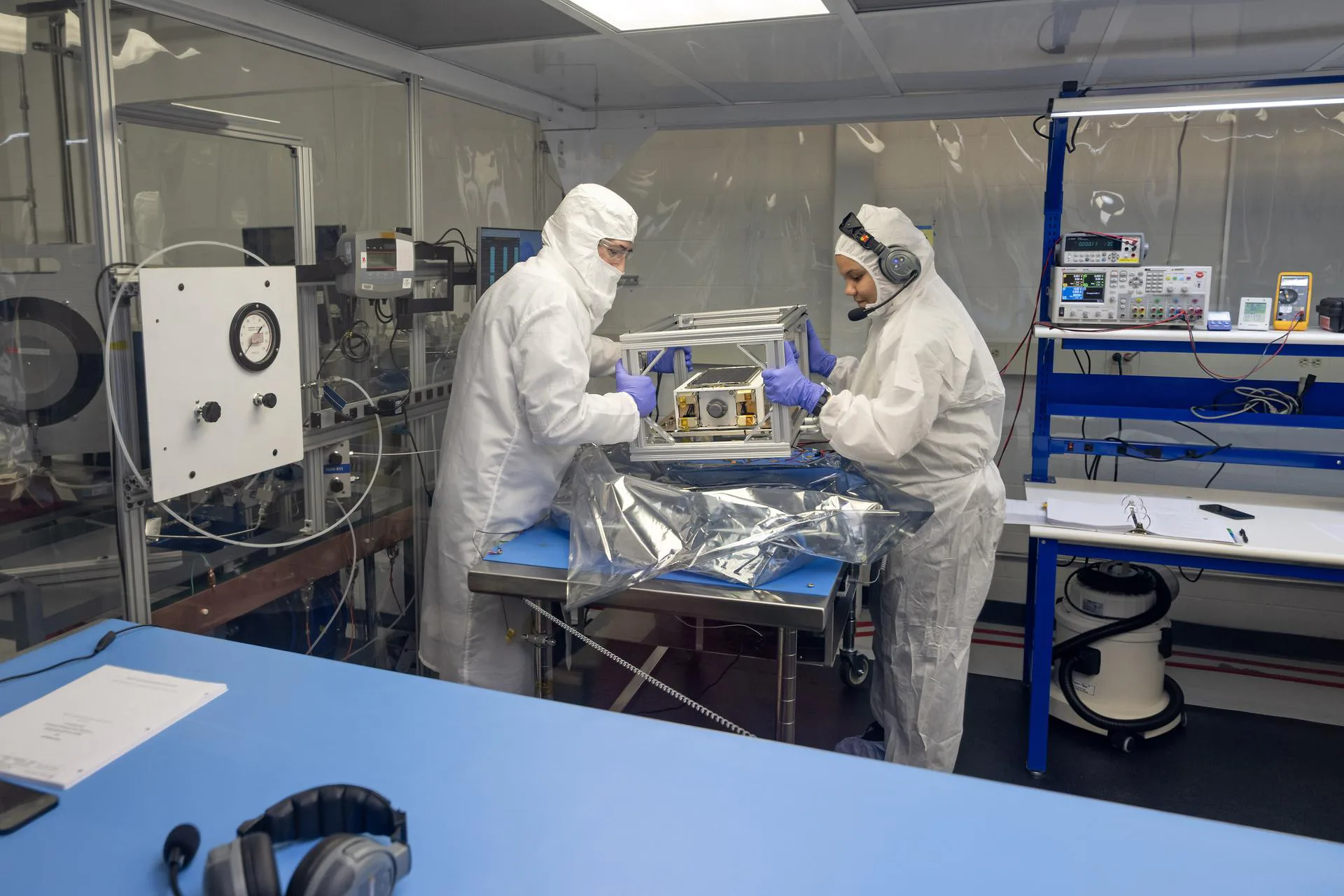 O especialista em propulsão Chris Burnside, à esquerda, e a líder de propulsão Ebony Bland, à direita, preparam o hardware de voo da missão para testes dentro de uma sala limpa no Centro de Voo Espacial Marshall da NASA, em Huntsville, Alabama. O CubeSat de 6-U passou recentemente por rigorosos testes de rotação, vácuo térmico e vazamento para garantir que seu inovador sistema de propulsão não tóxico esteja pronto para o ambiente extremo do espaço.