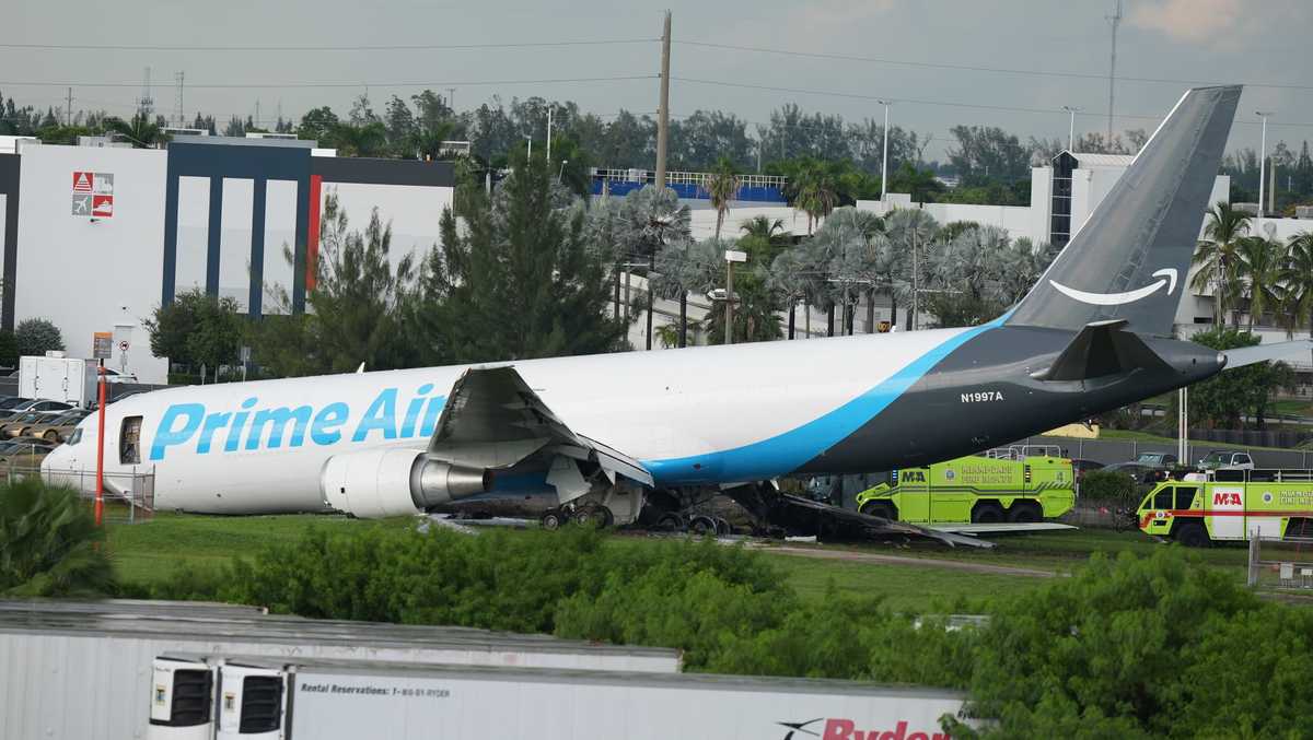 Aeronave de carga acidentada em pista de aeroporto, com veículos de emergência próximos e fuselagem danificada visível no local do incidente em Miami