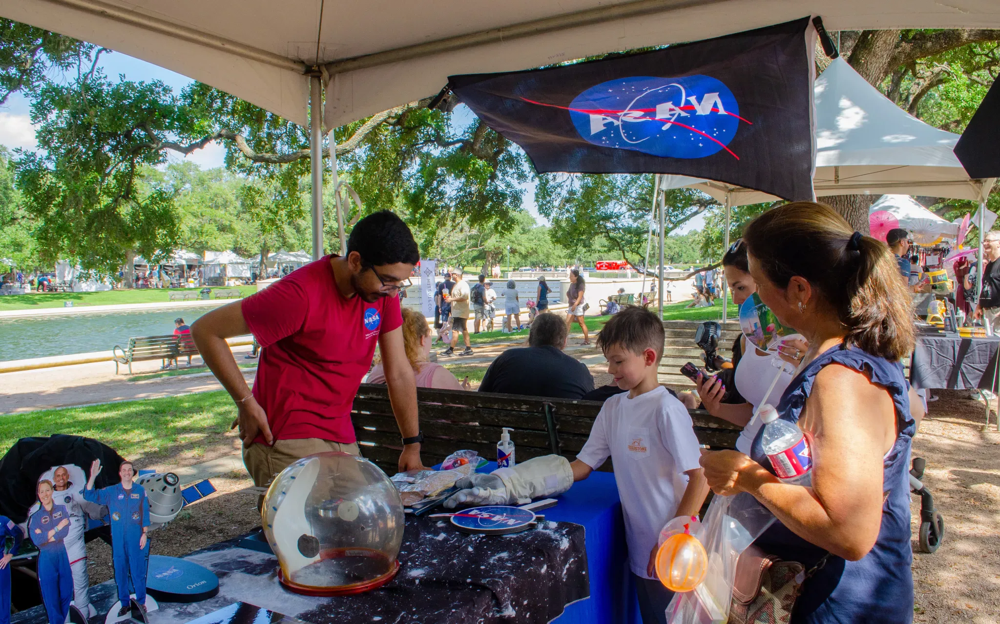 Voluntários do Centro Espacial Johnson da NASA compartilham informações sobre missões da NASA com os participantes do festival.
