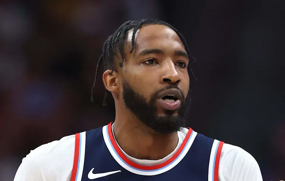 Jogador de basquete em uniforme de time da NBA durante partida, em close que mostra expressão concentrada durante o jogo