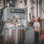 Um cervejeiro faz ajustes na unidade de captura de carbono da Earthly Labs, que purifica o dióxido de carbono do processo de fabricação de cerveja para uso na carbonatação.
