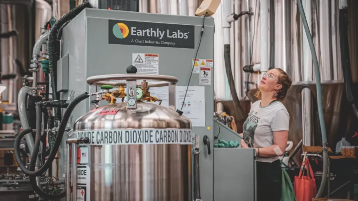 Um cervejeiro faz ajustes na unidade de captura de carbono da Earthly Labs, que purifica o dióxido de carbono do processo de fabricação de cerveja para uso na carbonatação.