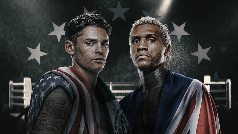 Dois boxeadores posam para foto de promoção de luta, usando roupas de treino com cores de bandeira americana, em frente a fundo com estrelas e rinque de boxe