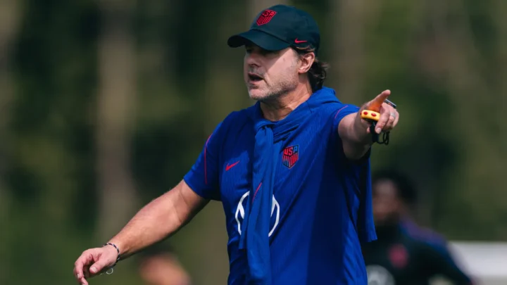 Técnico gesticula durante treino com uniforme azul da seleção americana de futebol