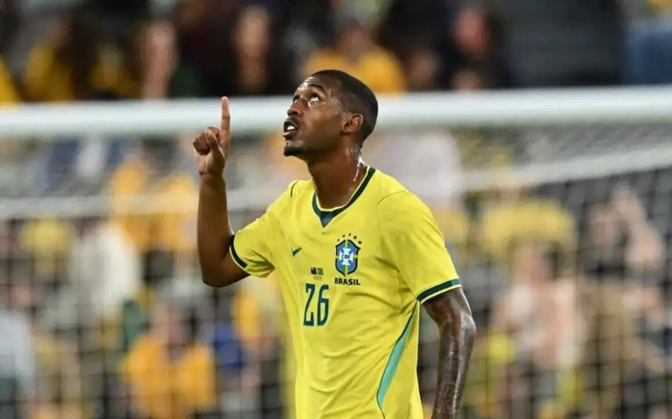 Jogador da seleção brasileira comemora durante partida contra a Austrália em estádio com torcedores ao fundo