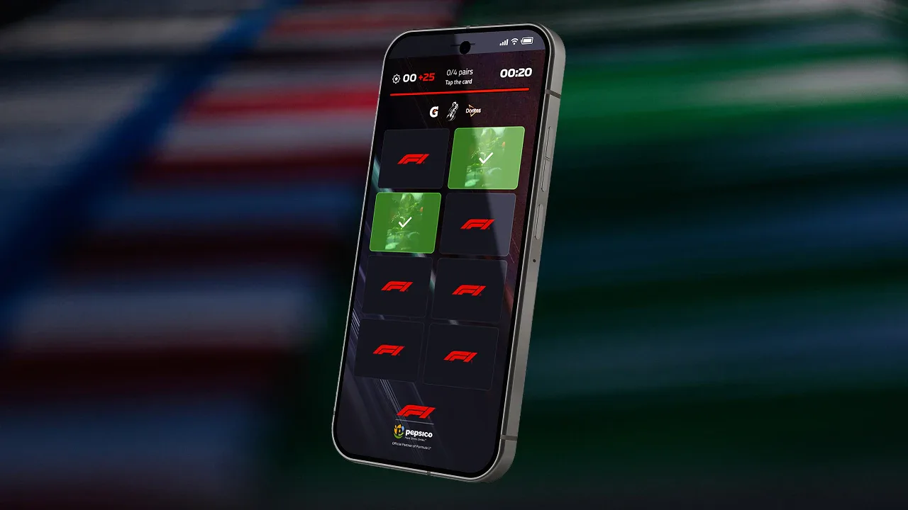 Smartphone exibe aplicativo de jogo com grade de cartas referente a competição automobilística, apresentando cards verdes com checkmarks e cards escuros com símbolos da categoria