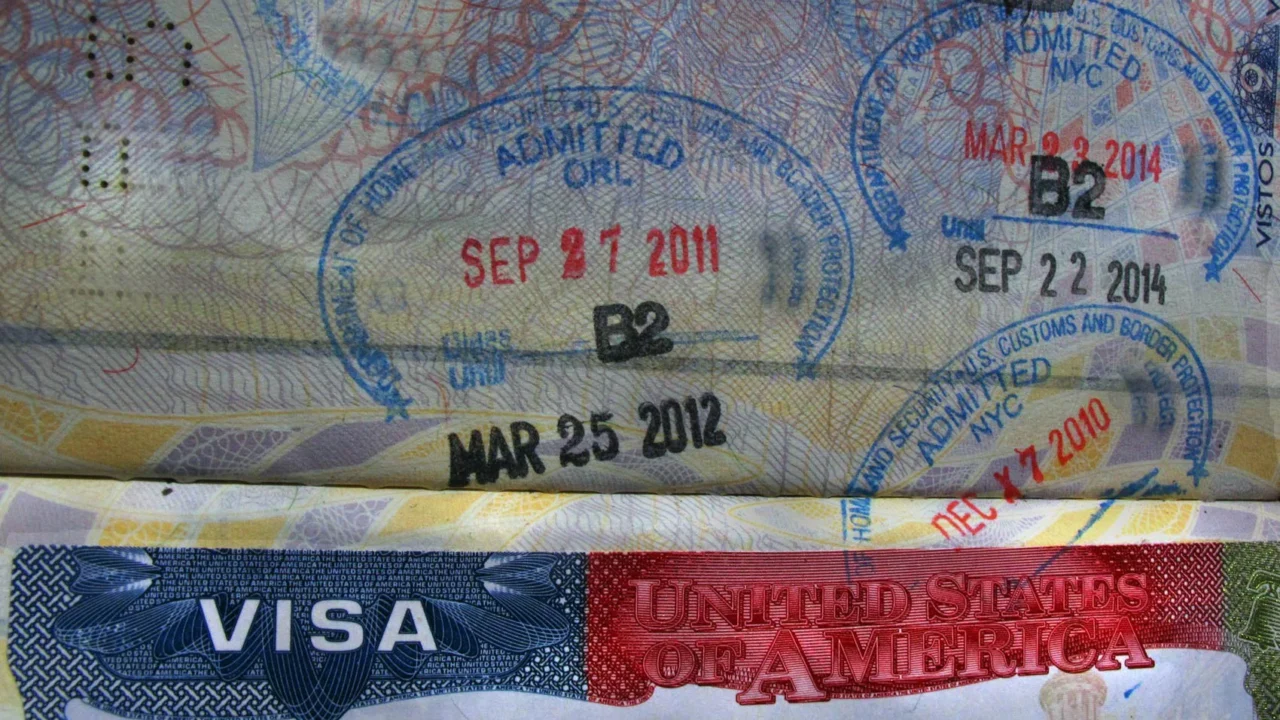 Detalhe de passaporte brasileiro com visto americano e múltiplos carimbos de entrada nos Estados Unidos datados entre 2010 e 2014