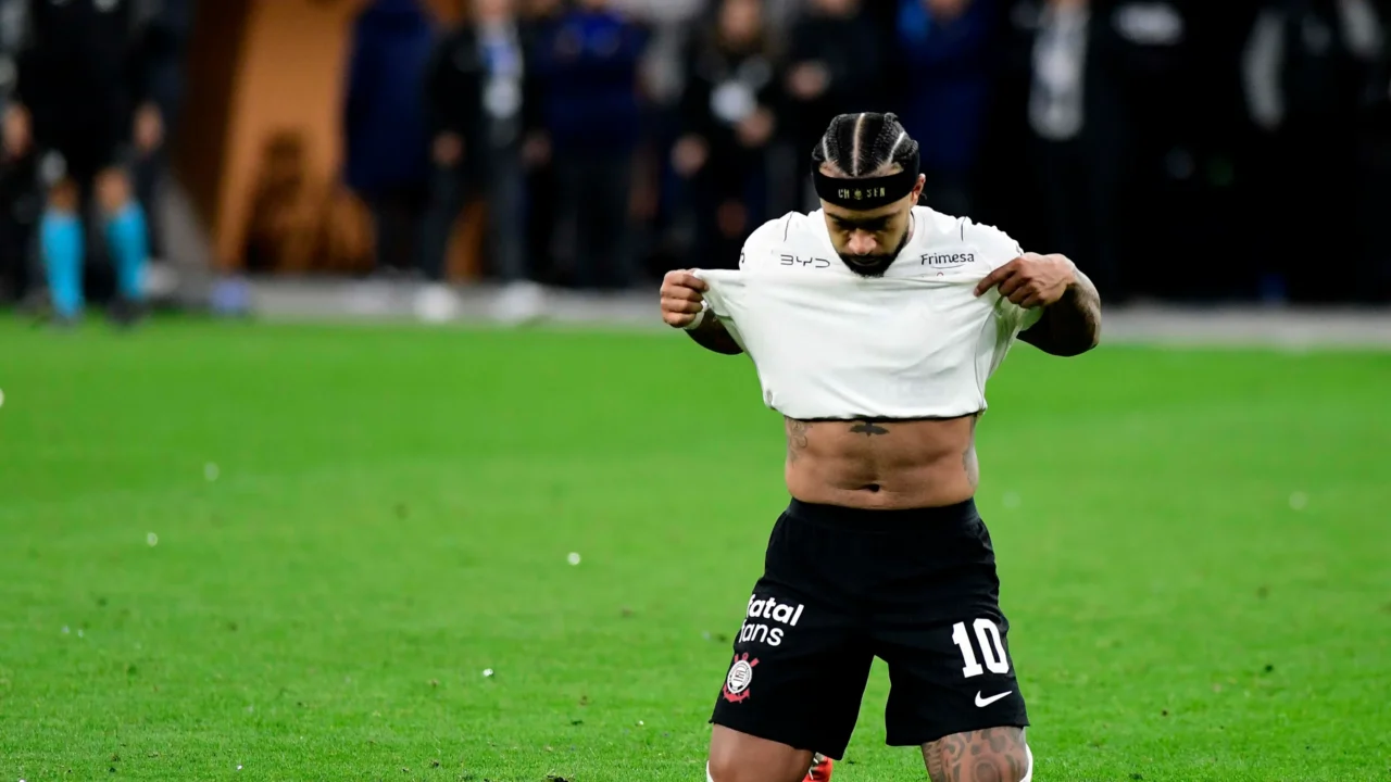 Jogador do Corinthians ajoelha no gramado após desperdiçar pênalti decisivo em partida pela Copa Libertadores, com torcedores ao fundo