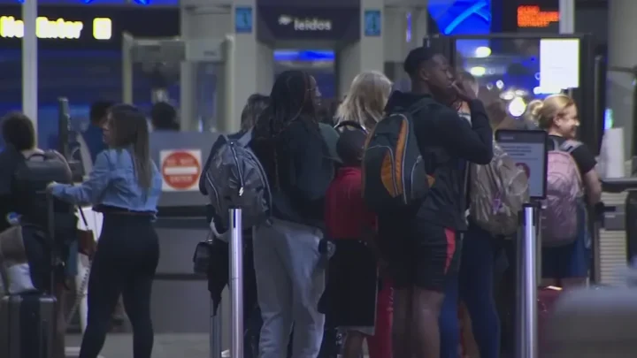 Passageiros aguardam em fila para passar por revista de segurança em terminal de aeroporto durante período de pico de viagens