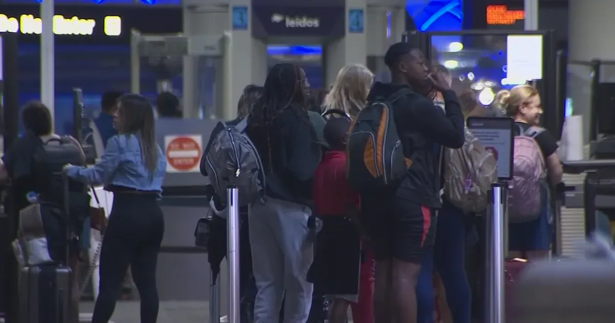 Passageiros aguardam em fila para passar por revista de segurança em terminal de aeroporto durante período de pico de viagens