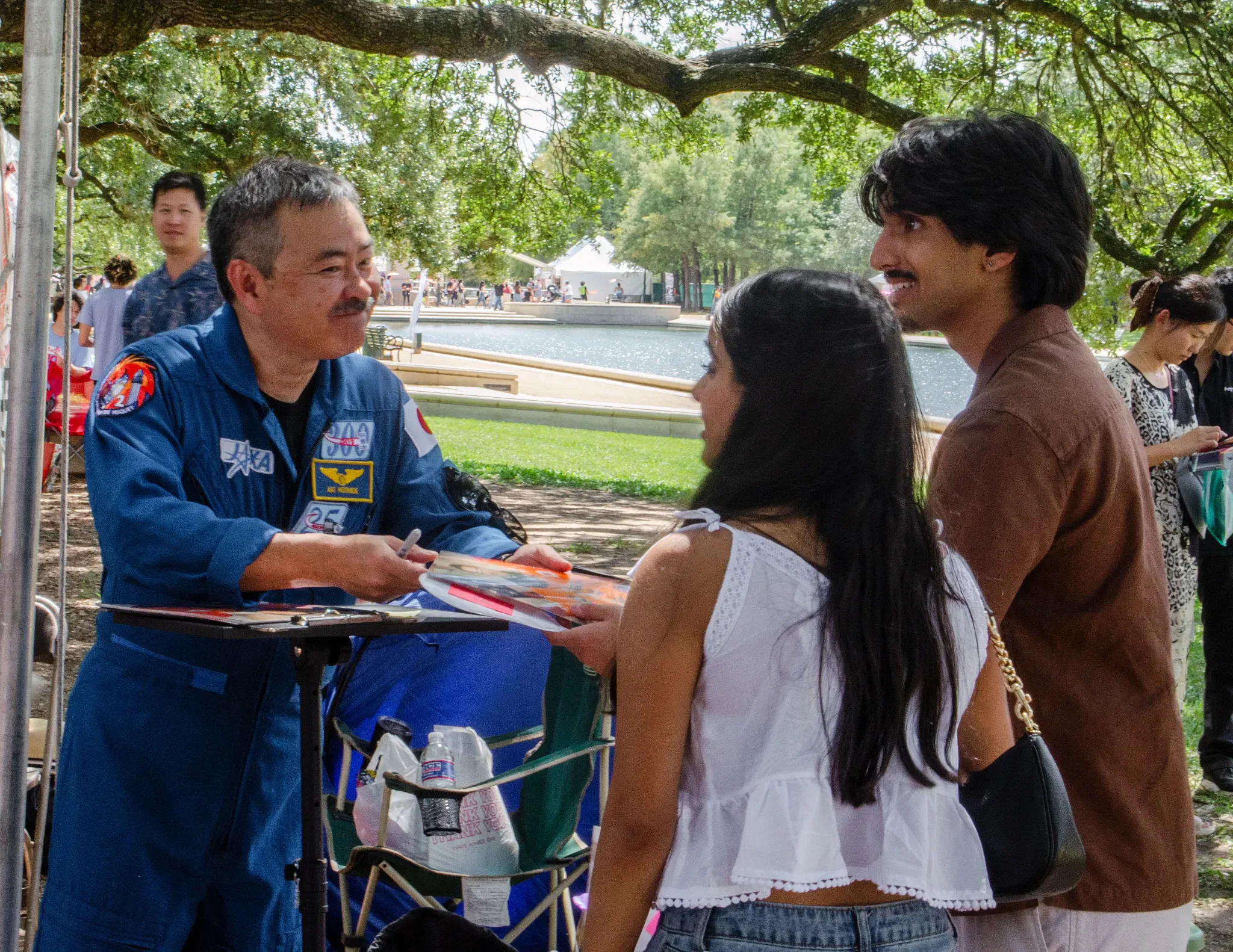 O astronauta da JAXA (Agência de Exploração Aeroespacial do Japão) Akihiko Hoshide autografa e posa para fotos com participantes do festival.
