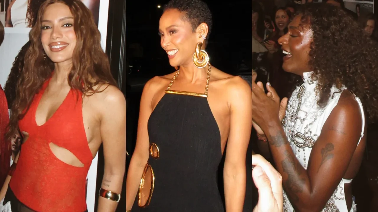 Três mulheres em evento de gala noturno: uma de vestido vermelho à esquerda, outra de preto e dourado ao centro, e a terceira com roupa branca com aplicações na direita, sorrindo