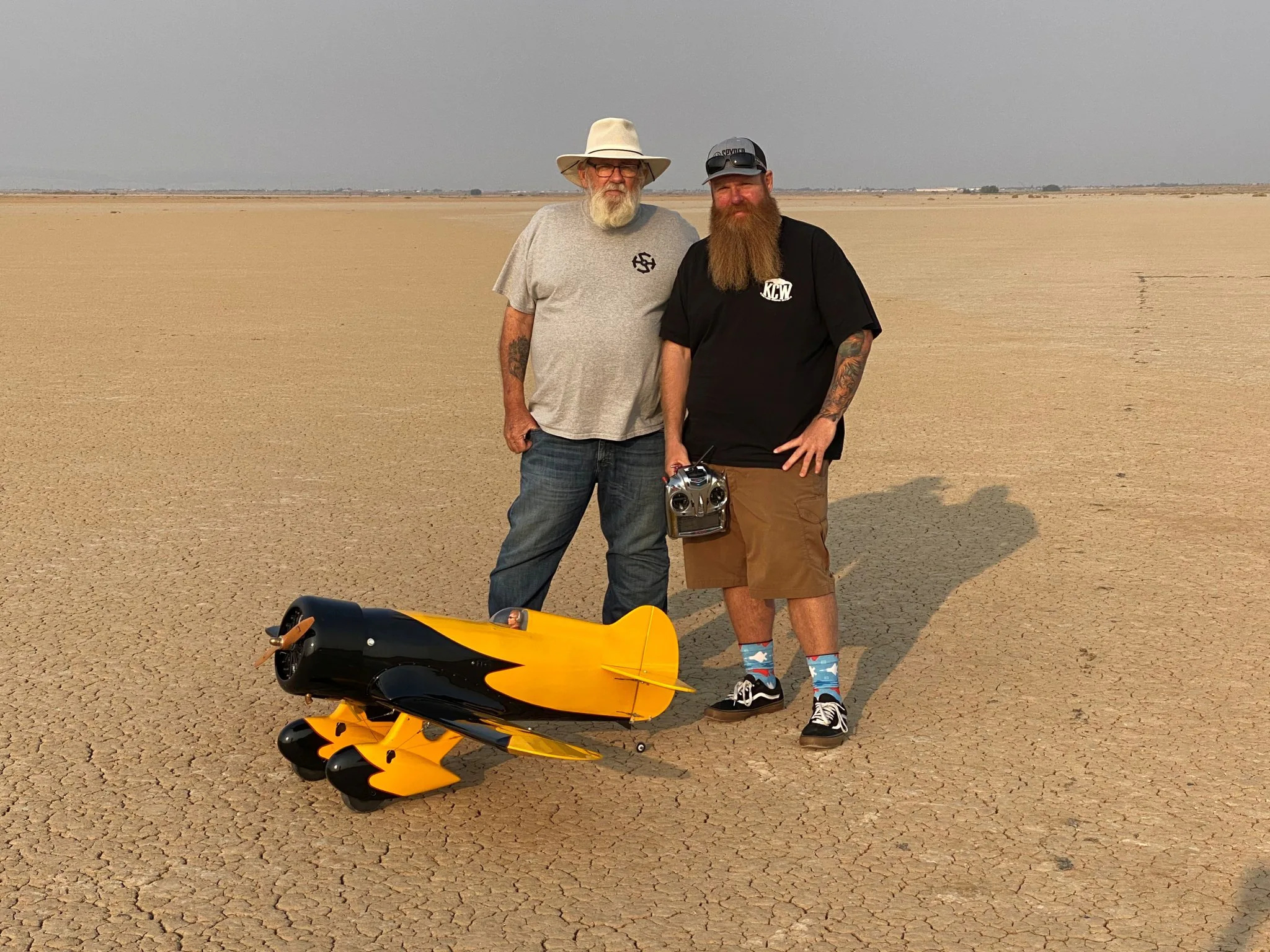 Justin Hall, piloto-chefe do Laboratório de Pesquisa de Voo em Escala Reduzida Dale Reed, no Centro de Pesquisa de Voo Armstrong da NASA, em Edwards, Califórnia, aparece em pé diante de uma aeronave controlada por rádio com seu pai, David Hall. David Hall construiu a aeronave Gee Bee anos antes, mas não conseguiu voar com ela devido à sua saúde. Ele pediu ao filho que voasse com a aeronave para que pudesse vê-la no ar, o que Justin fez no dia desta foto. Pouco depois, David Hall faleceu.