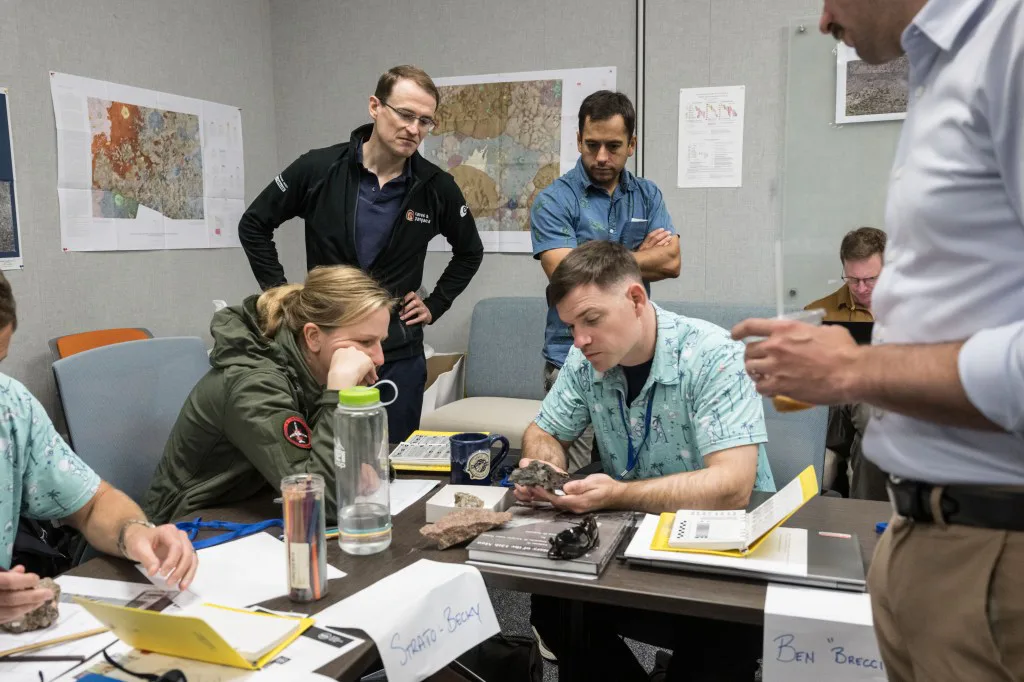 Candidatos a astronauta da NASA estudam amostras de rochas durante um treinamento de geologia em sala de aula no Centro Espacial Johnson da NASA, em Houston.