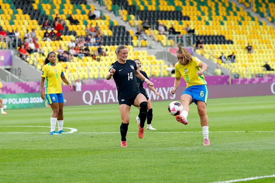 Jogadora da seleção brasileira em uniforme amarelo disputa a bola com atleta dos EUA, vestida de preto, durante partida do Mundial Sub-20 feminino na Polônia
