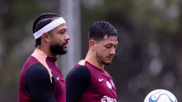 Dois jogadores do Corinthians em uniforme de treino junto a uma bola durante atividade no centro de treinamento do clube