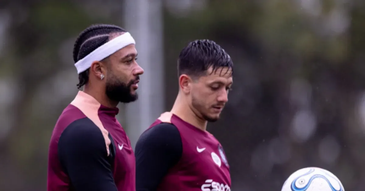 Dois jogadores do Corinthians em uniforme de treino junto a uma bola durante atividade no centro de treinamento do clube