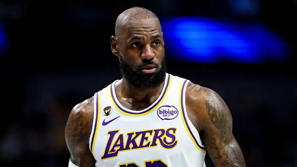Jogador de basquete em uniforme branco e roxo do Lakers durante partida na quadra