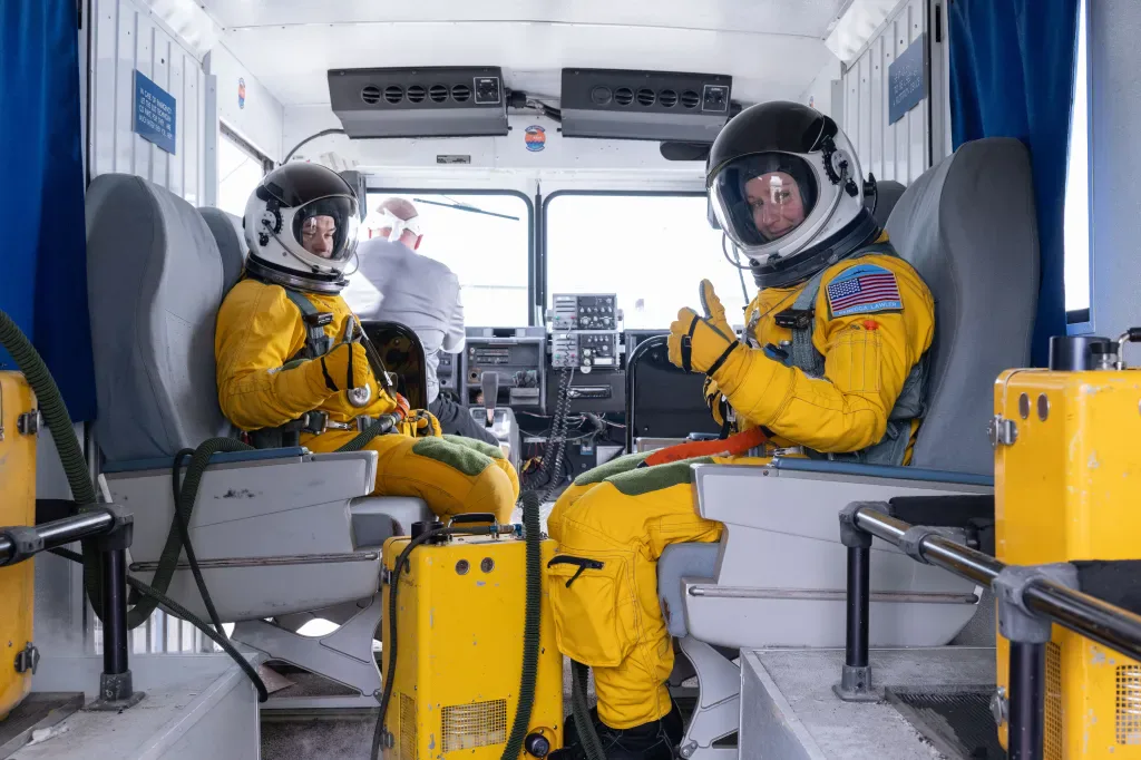 A candidata a astronauta da NASA Rebecca Lawler, à direita, se dirige a uma das aeronaves WB-57 da NASA antes do treinamento de voo no Ellington Field.