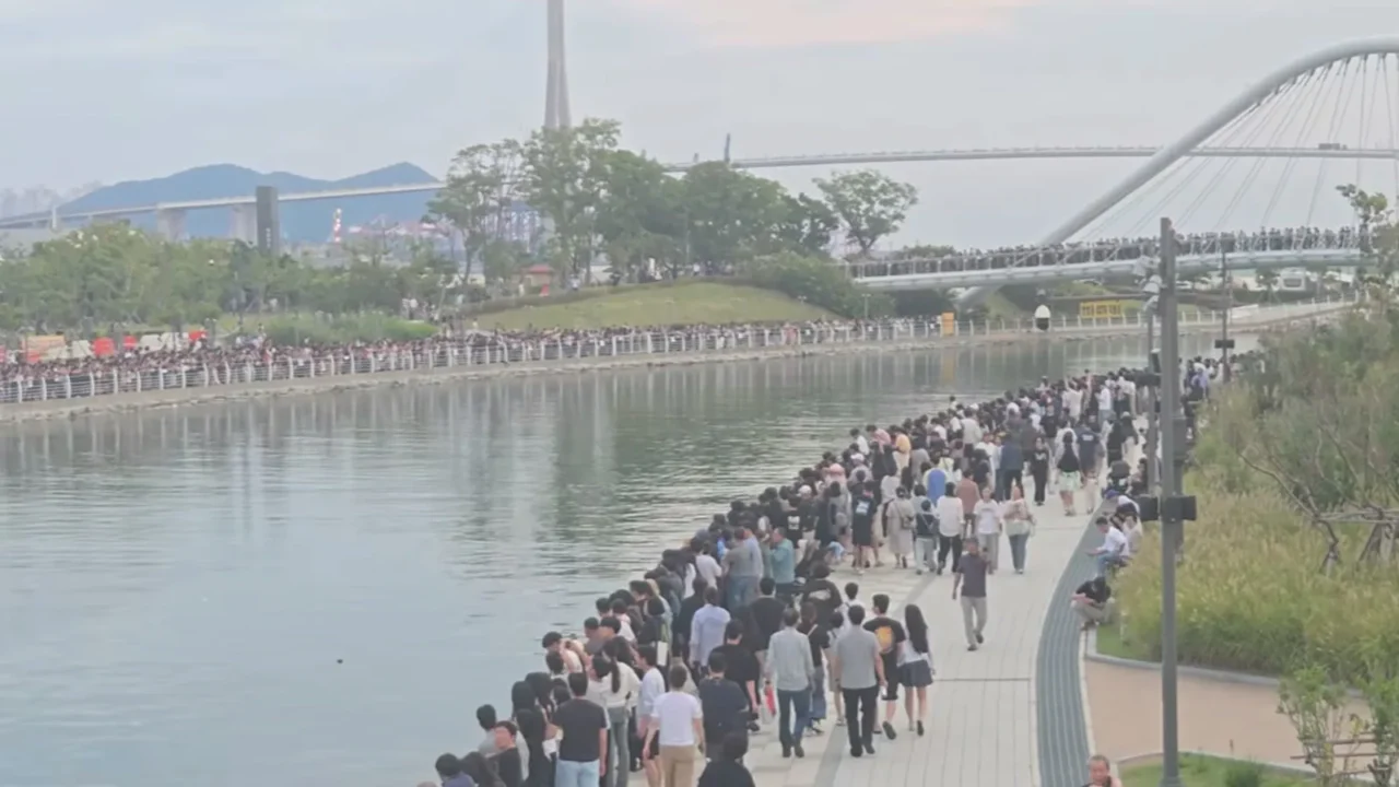 Multidão se espreme na margem do canal do parque à beira-mar do porto norte de Busan, na Coreia do Sul, em 30 de setembro de 2026, com uma ponte em arco ao fundo