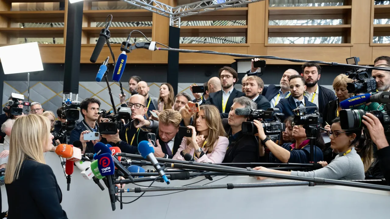 A primeira-ministra da Itália, Giorgia Meloni, fala a dezenas de jornalistas com microfones e câmeras em Bruxelas, em março de 2023 (imagem de arquivo)