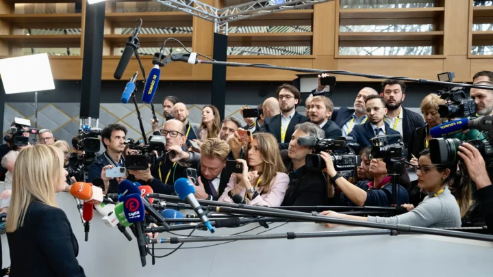 A primeira-ministra da Itália, Giorgia Meloni, fala a dezenas de jornalistas com microfones e câmeras em Bruxelas, em março de 2023 (imagem de arquivo)