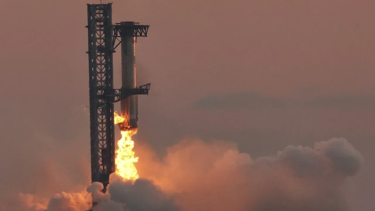 Braços da torre de Starbase, no Texas, seguram o propulsor Super Heavy no 5º voo de teste da Starship, em outubro de 2024 (imagem de arquivo)