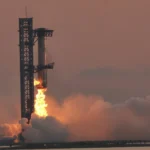 Braços da torre de Starbase, no Texas, seguram o propulsor Super Heavy no 5º voo de teste da Starship, em outubro de 2024 (imagem de arquivo)