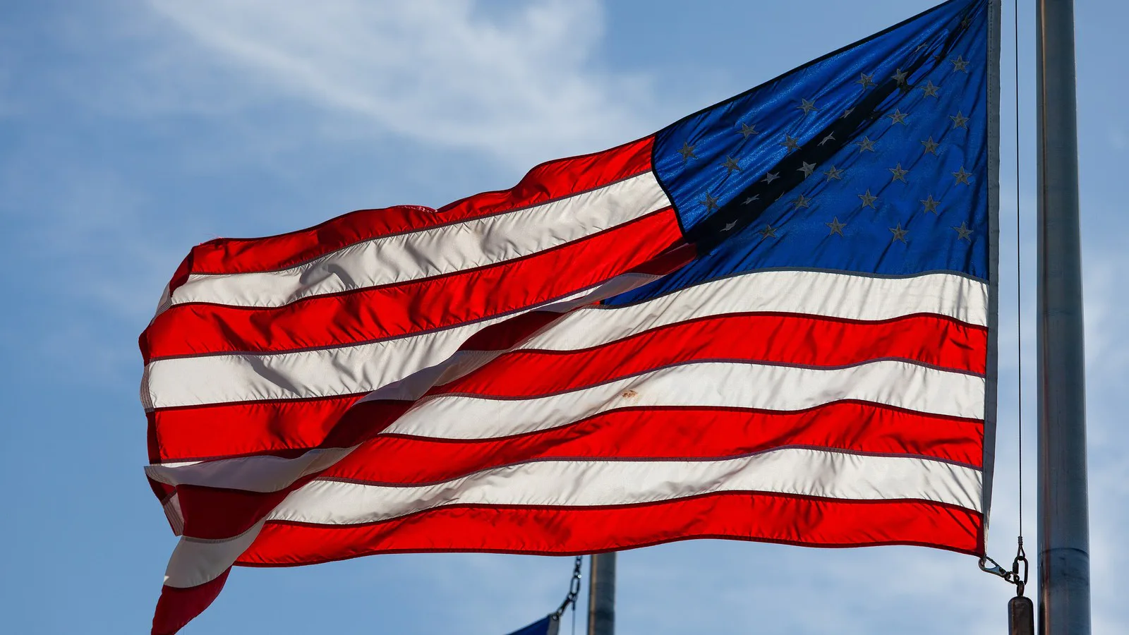 Bandeira dos Estados Unidos tremulando contra o céu azul, em foto de arquivo
