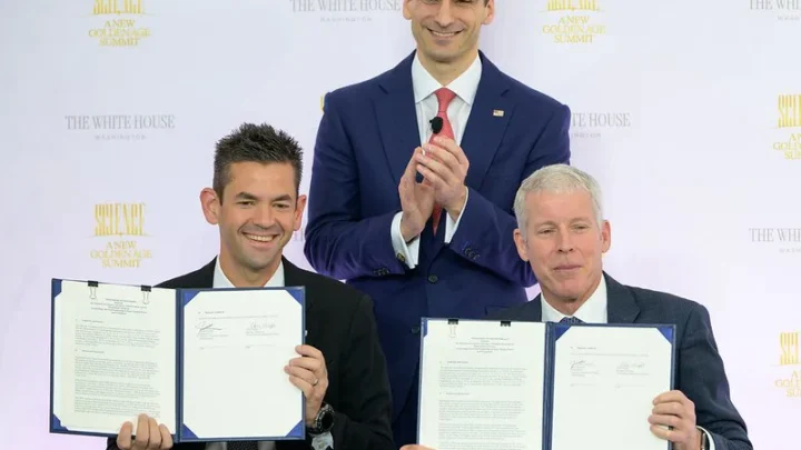 O administrador da NASA, Jared Isaacman, sentado à esquerda, e o secretário de Energia dos EUA, Chris Wright, sentado à direita, seguram o Memorando de Entendimento assinado