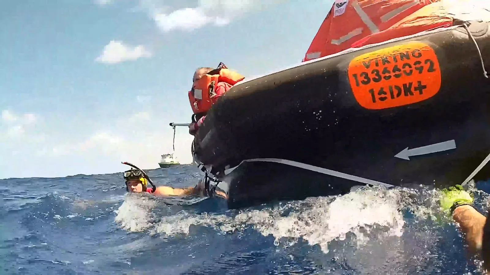 Nadador de resgate da Guarda Costeira junto a uma balsa salva-vidas