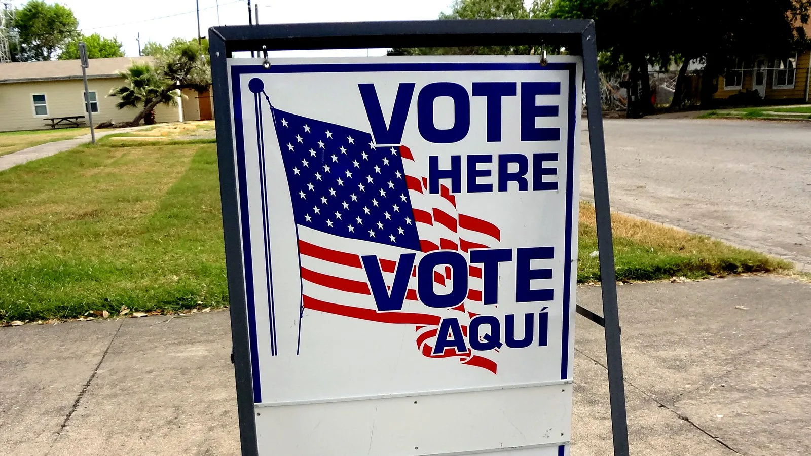 Placa "Vote Here / Vote aquí", com a bandeira dos Estados Unidos, na calçada de um local de votação em Taft, no Texas (imagem de arquivo)