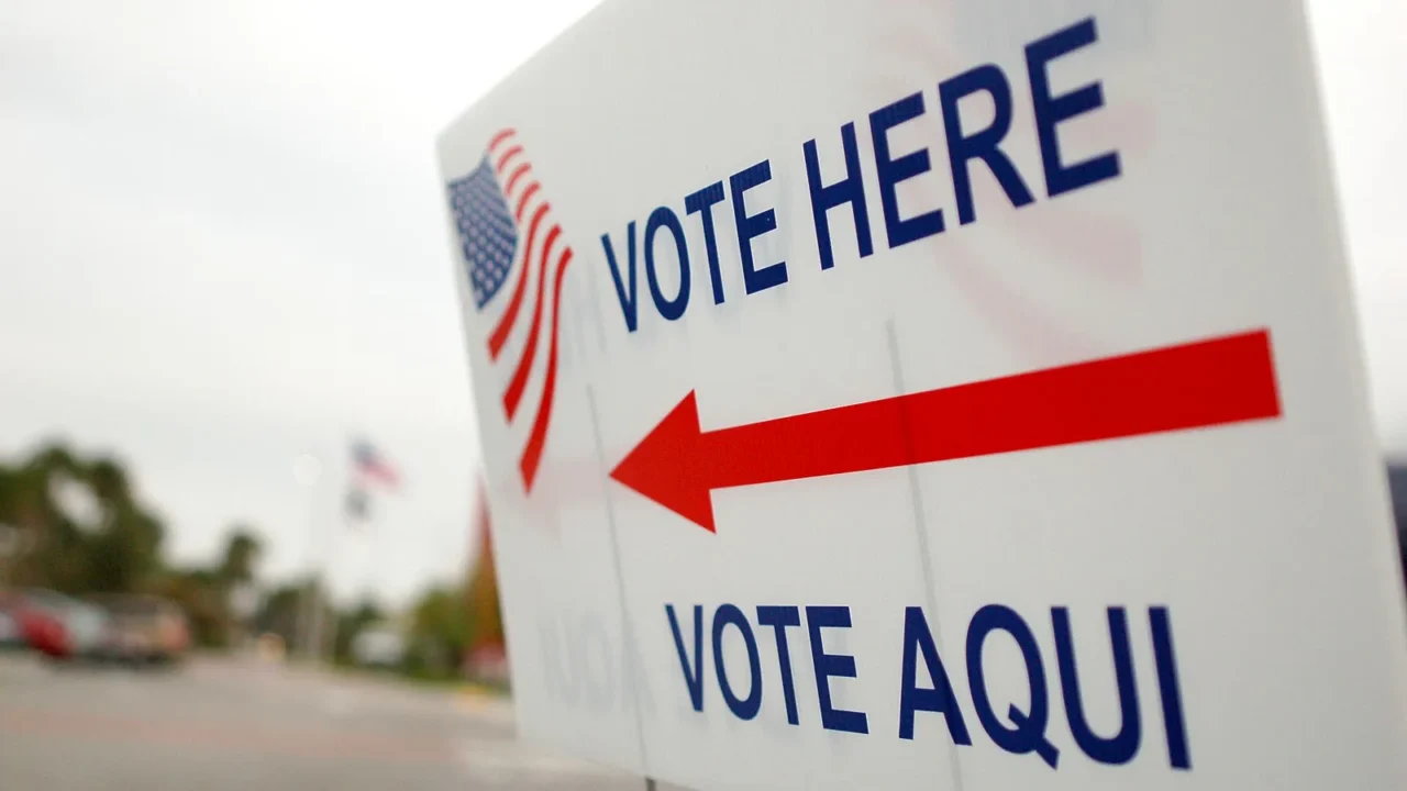 Placa bilíngue "Vote here / Vote aqui", com bandeira dos Estados Unidos e seta vermelha, na entrada de um local de votação em Orlando, na Flórida, em novembro de 2008 (imagem de arquivo)