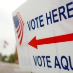 Placa bilíngue "Vote here / Vote aqui", com bandeira dos Estados Unidos e seta vermelha, na entrada de um local de votação em Orlando, na Flórida, em novembro de 2008 (imagem de arquivo)