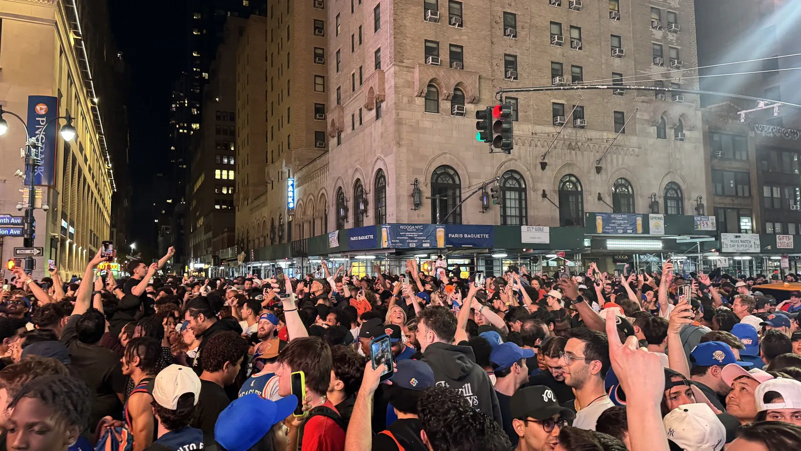 Multidão de torcedores dos Knicks comemora na rua, à noite, perto do Madison Square Garden, durante as finais de 2026