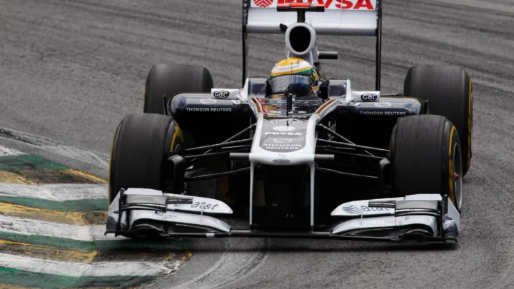 Carro da Williams com pintura branca e azul, patrocinado pela PDVSA, contorna uma curva de zebrada verde, amarela e branca em circuito de asfalto