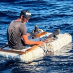 Homem sozinho numa balsa improvisada de isopor, tábuas e cordas, em mar aberto