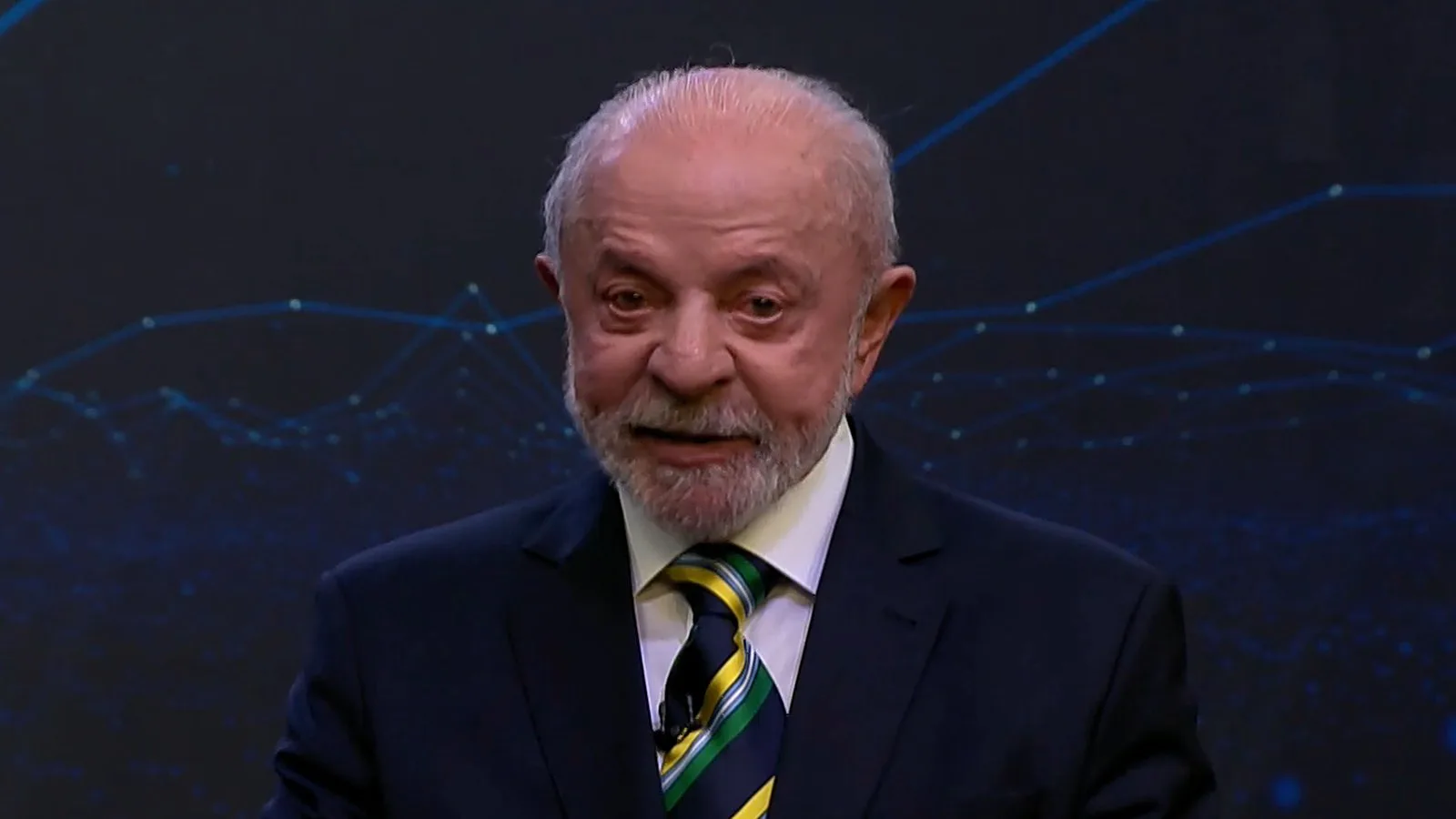 Lula, de terno escuro e gravata verde e amarela, fala no primeiro confronto direto