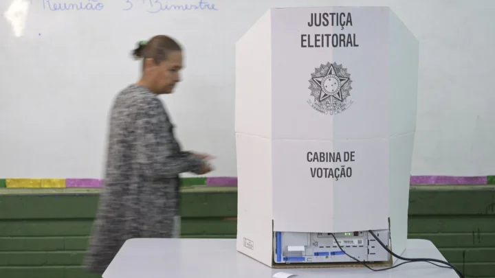 Pessoa passa ao lado de uma cabina de votação da Justiça Eleitoral na 17ª Zona Eleitoral, no Gama, no Distrito Federal, no 1º turno, em 4 de outubro de 2026