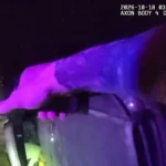 Imagem de câmera corporal mostra a mão de um policial apoiada sobre o veículo tombado de lado, à noite, em North Fort Myers, na Flórida, em 18 de outubro