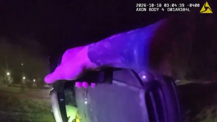 Imagem de câmera corporal mostra a mão de um policial apoiada sobre o veículo tombado de lado, à noite, em North Fort Myers, na Flórida, em 18 de outubro